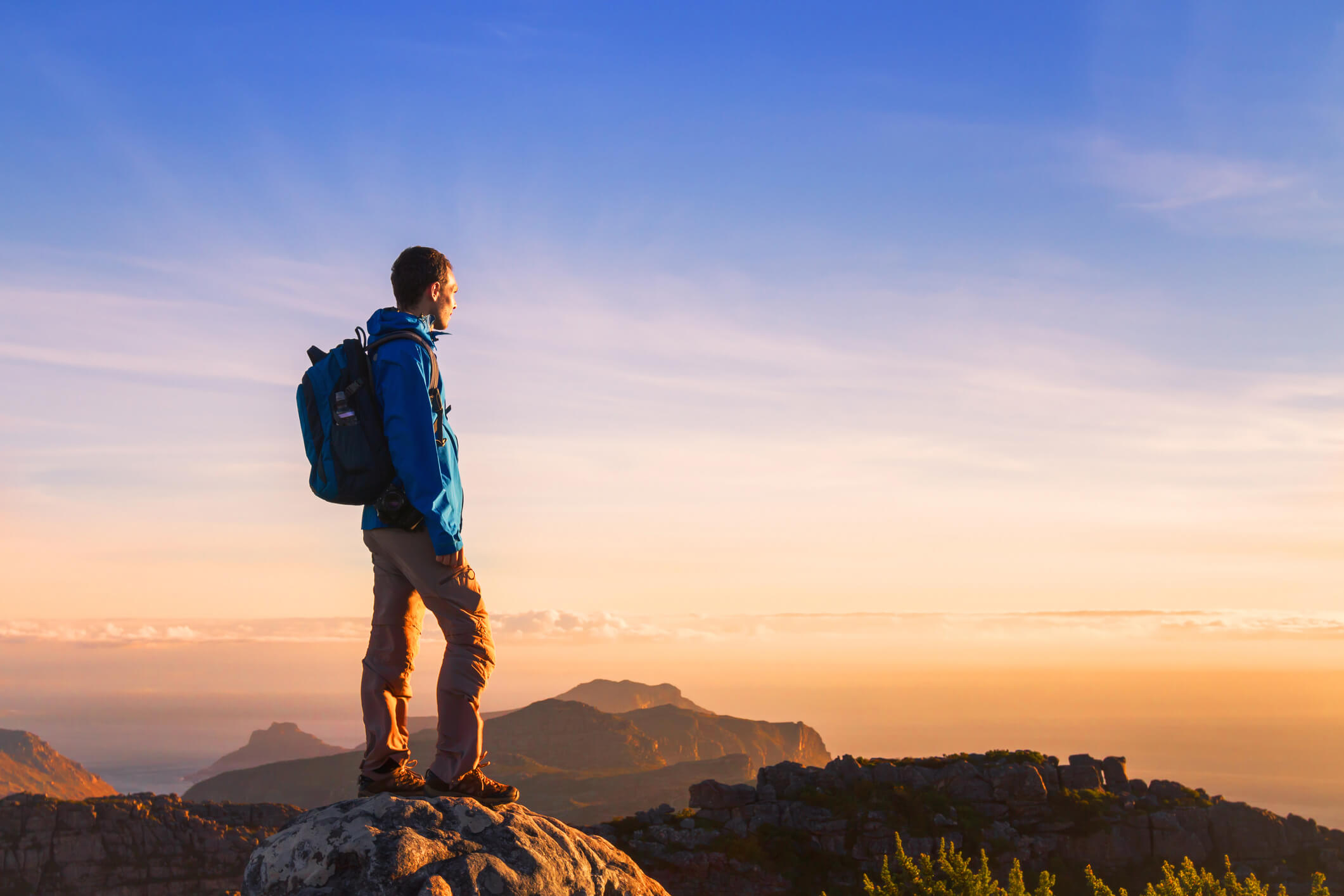 a hiking man looking at the sunset