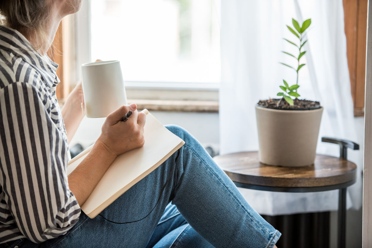 A woman with a notepad writing her reflections.