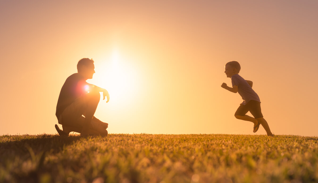 A young child running toward his father.