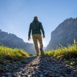 Man walking down a stony path.
