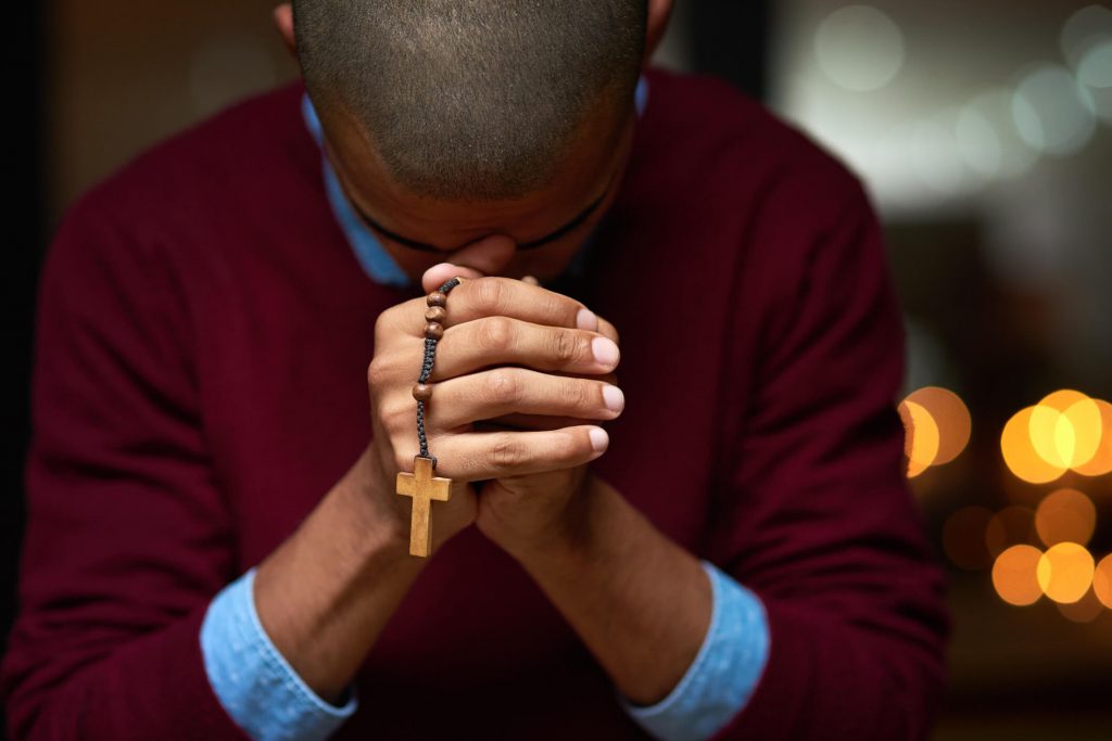 A man praying the rosary.