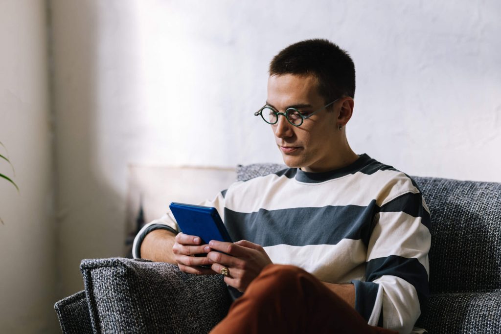 A curious young man looking things up with his phone.