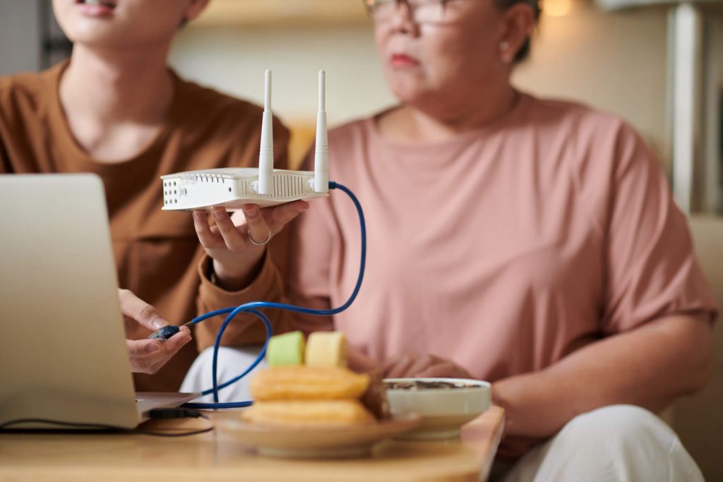 Middle-aged woman and a young boy setting up a router.