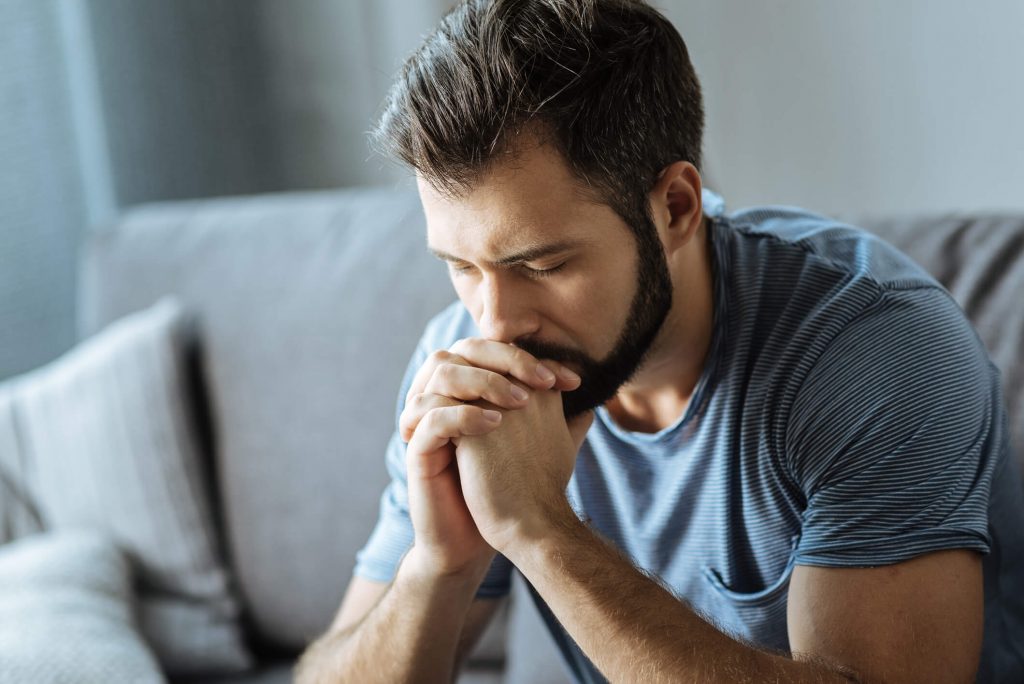Young man praying for victory against porn.