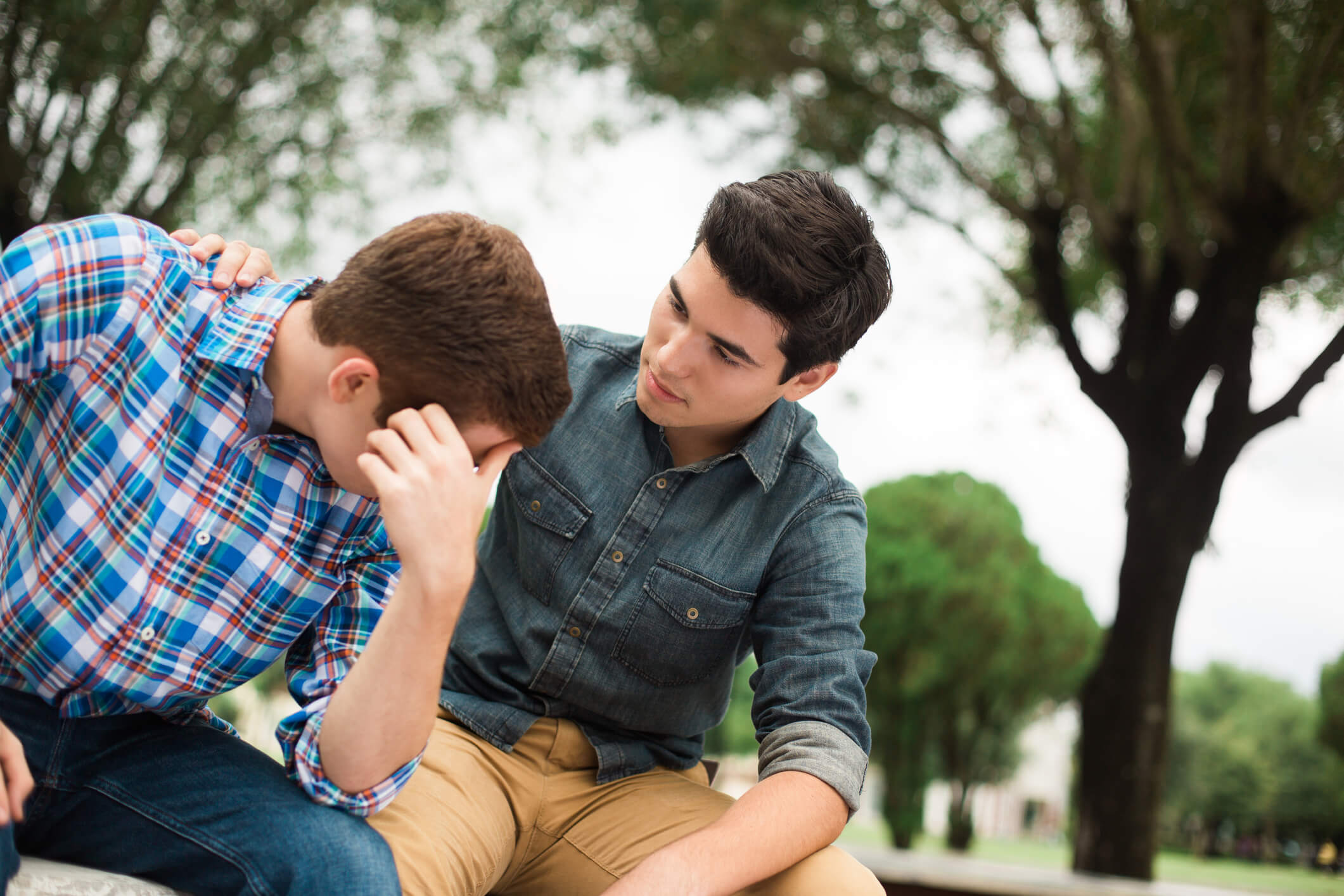 Young man comforting his friend, who is ashamed.