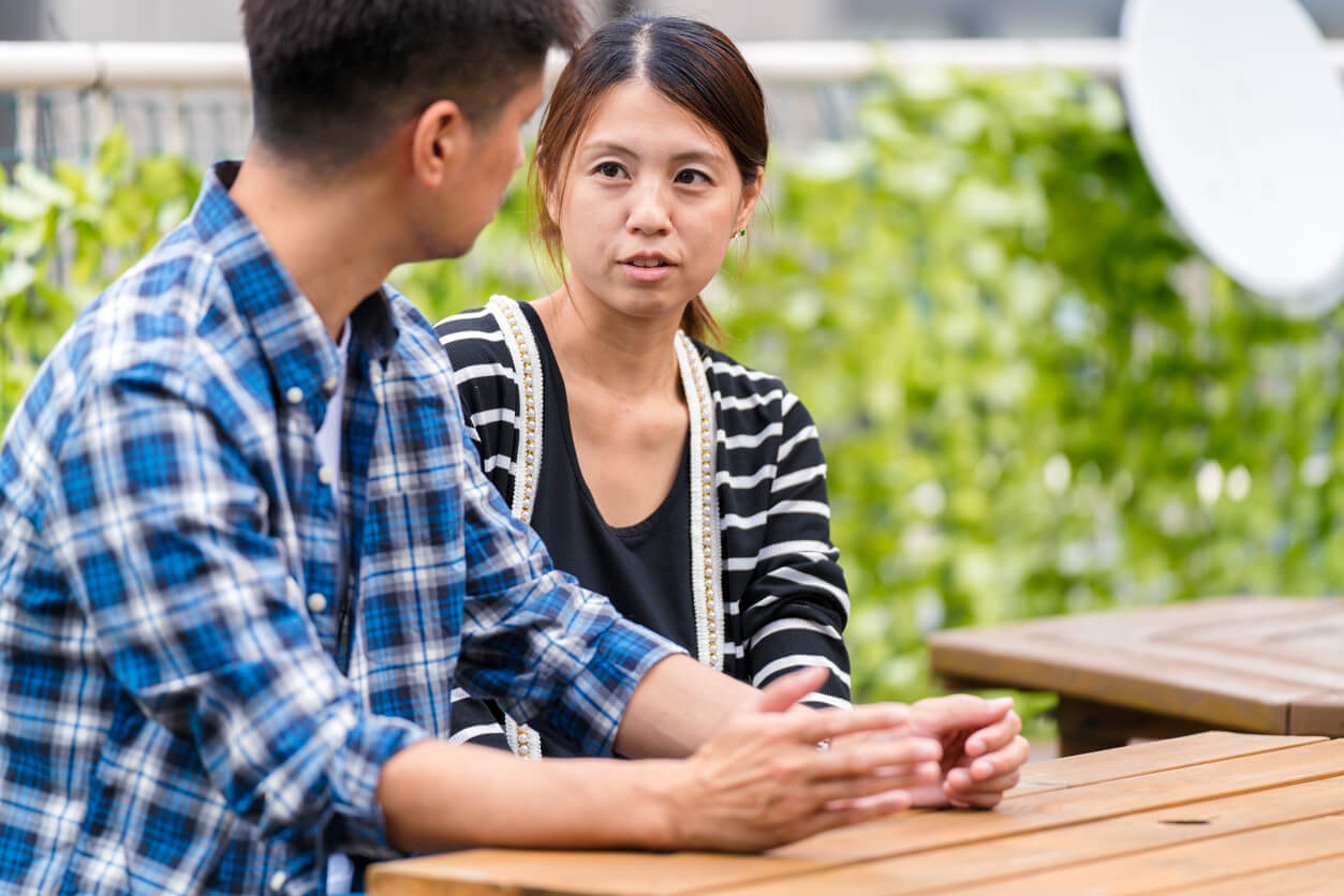 A husband and wife having a serious conversation outside.