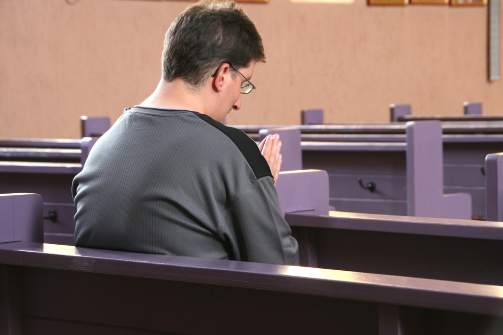 Man sitting in church praying to be free from porn.