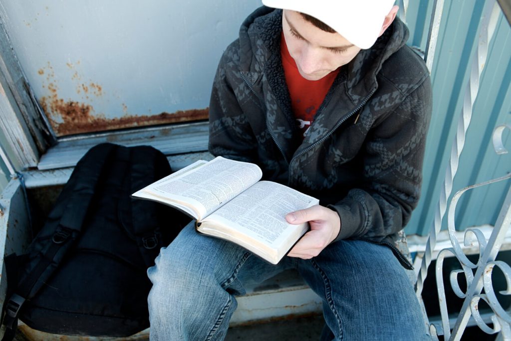 A teenager reading his Bible and learning about integrity.