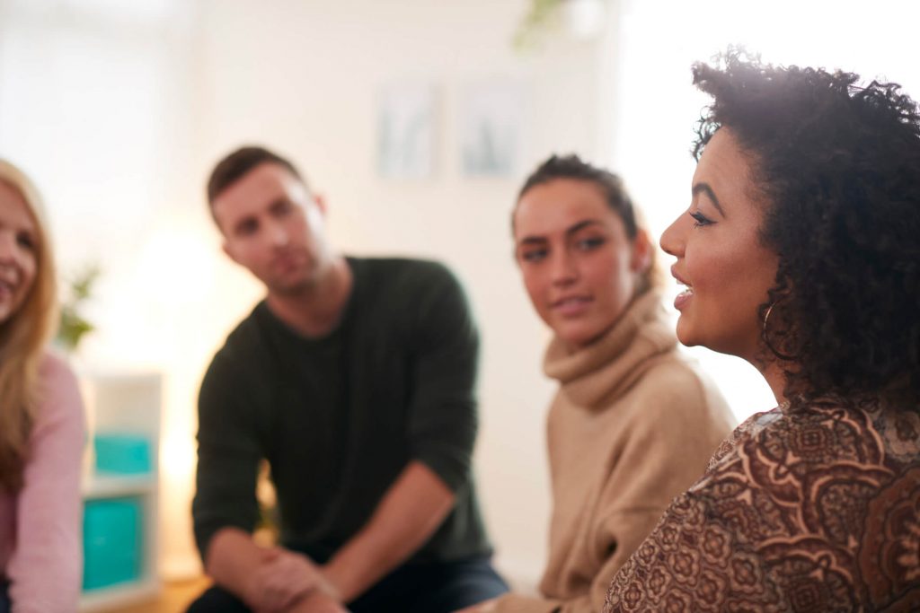 A woman sharing about church resources with a group.