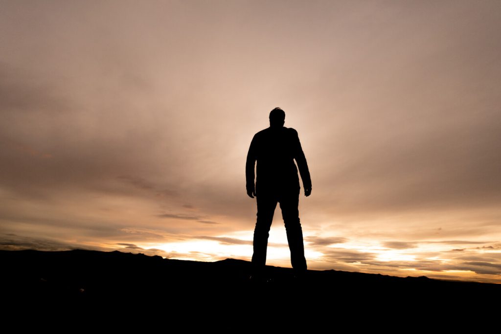 silhouette of a man standing on a hill