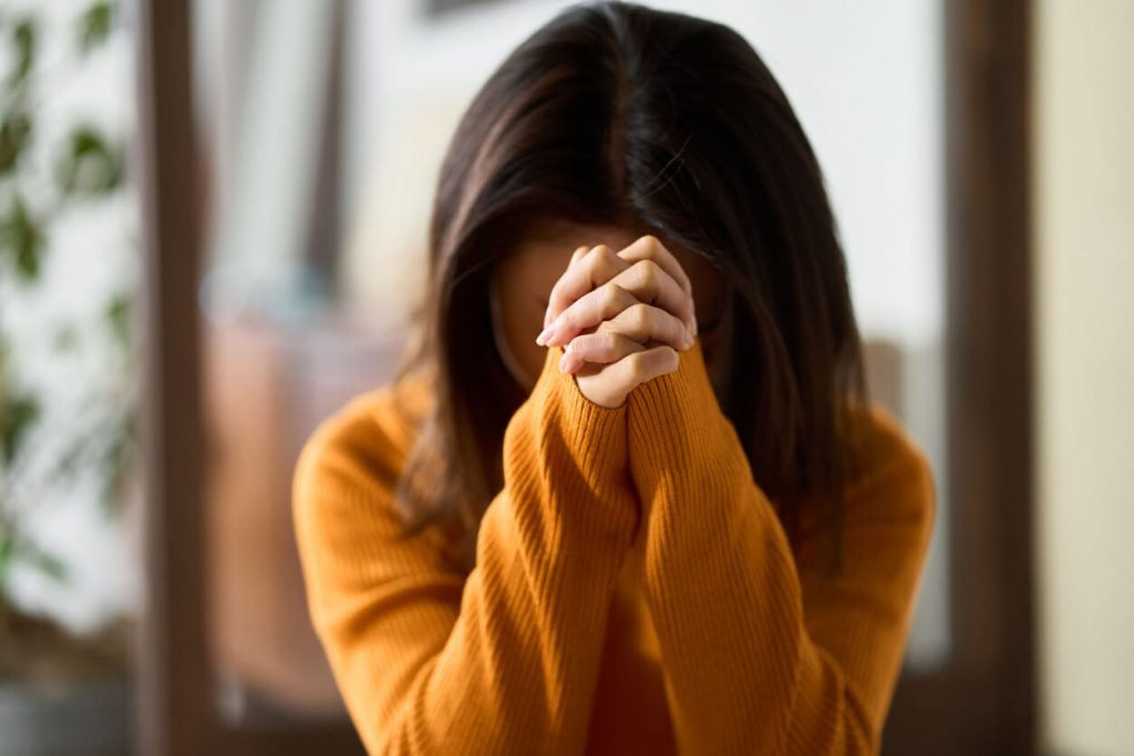 A woman praying with folded hands.