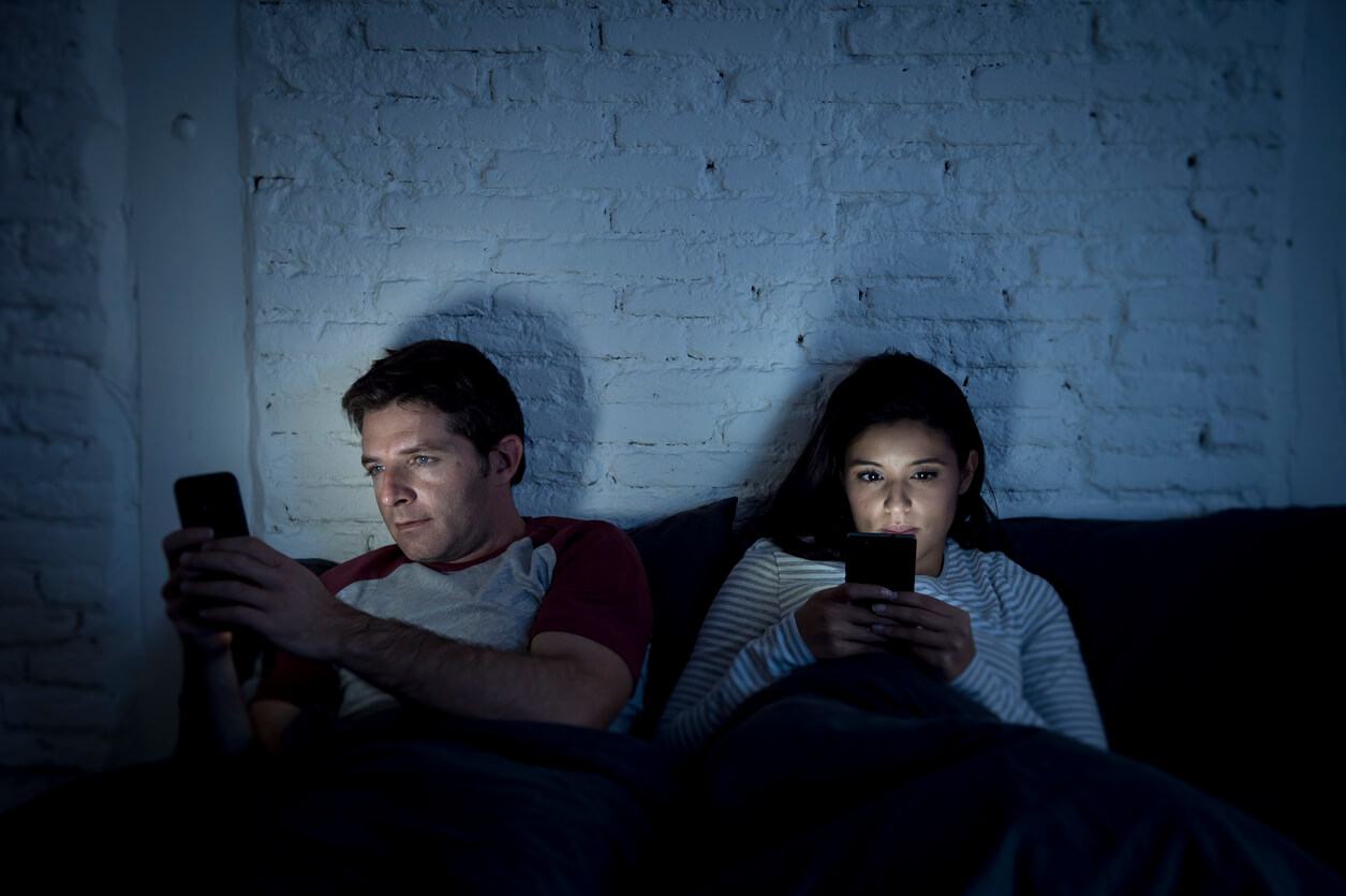 A normal couple in bed watching porn.