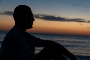 Silhouette of a man looking at the sea.