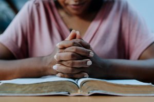 A woman praying with her Bible.