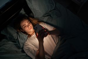 A teenage girl alone at night with her phone.