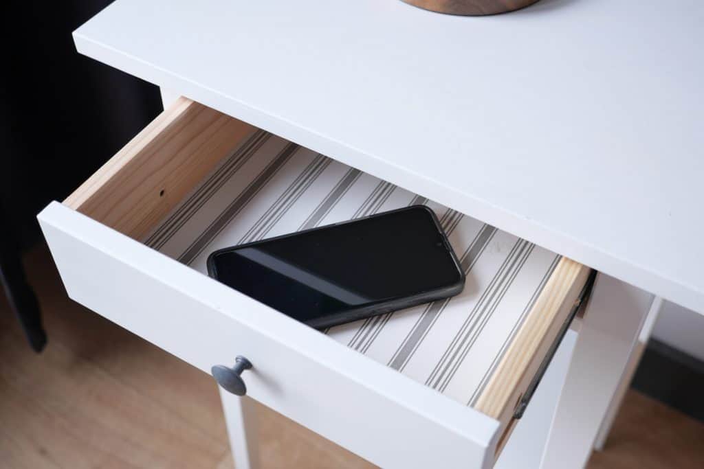 An open drawer with a phone in it.