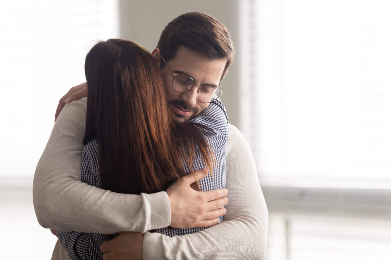 A young man embracing his wife.