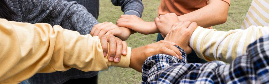 Close-up on the hands of a group of people learning to trust one another.