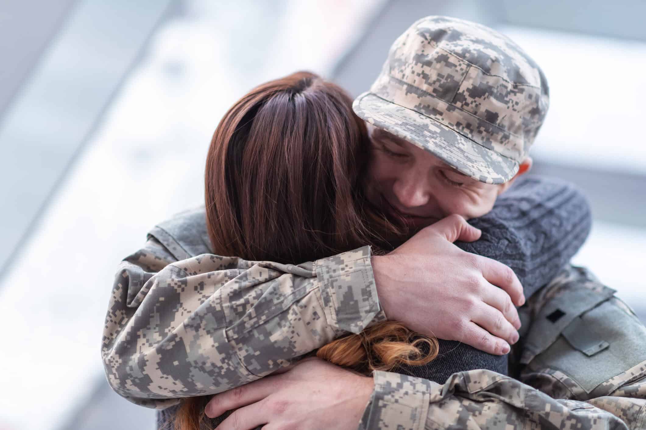 Man hugging his wife after returning home from service.