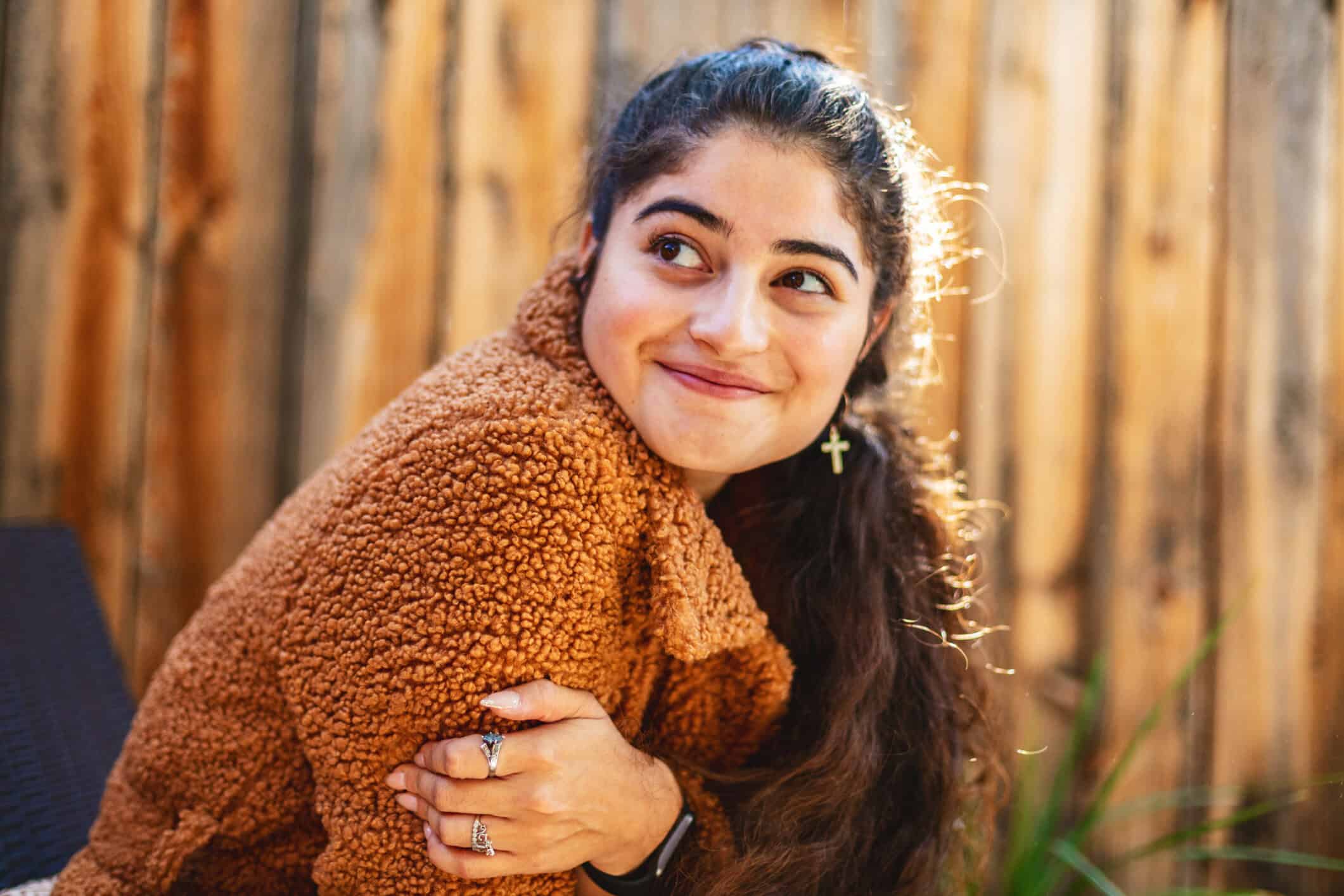 A thoughtful and smiling young woman.