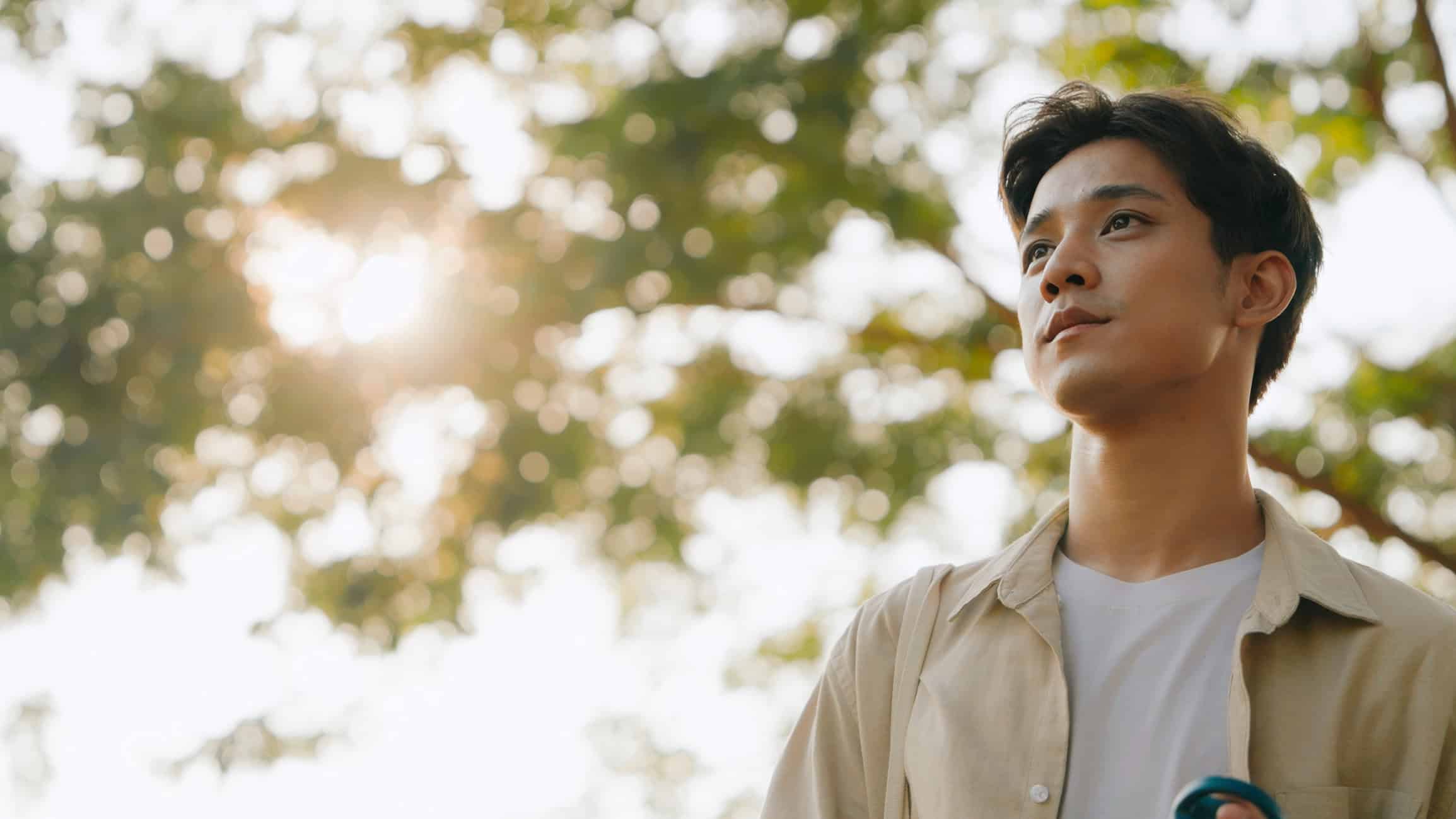 A young man outside in the sunlight.