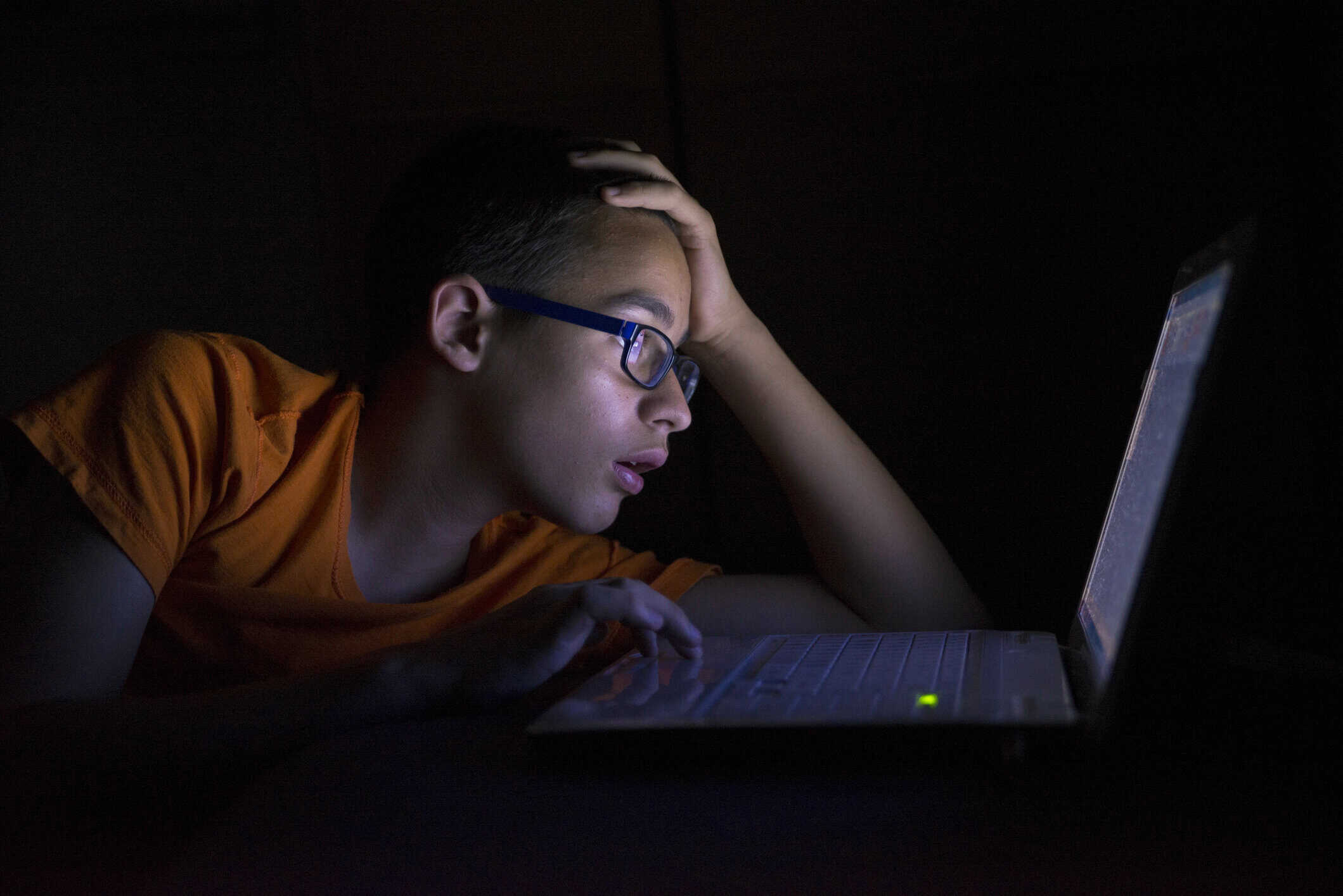 A teenage boy looking at a computer screen.