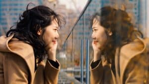 A young woman looking at her reflection.