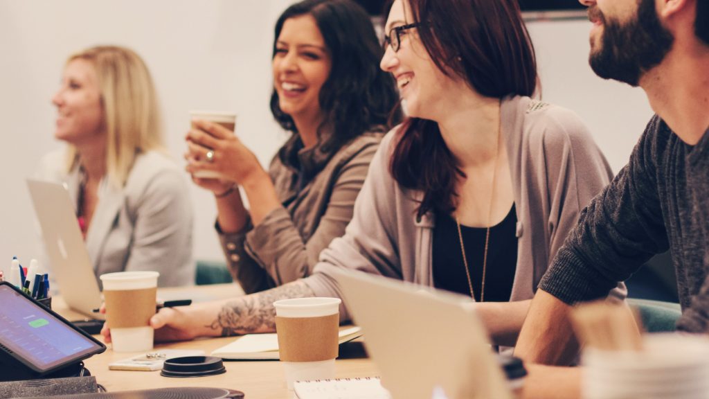 Photo shows three women and a man collaborating at Covenant Eyes conference table.
