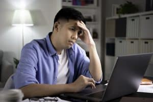 Concerned man looking at a computer screen.