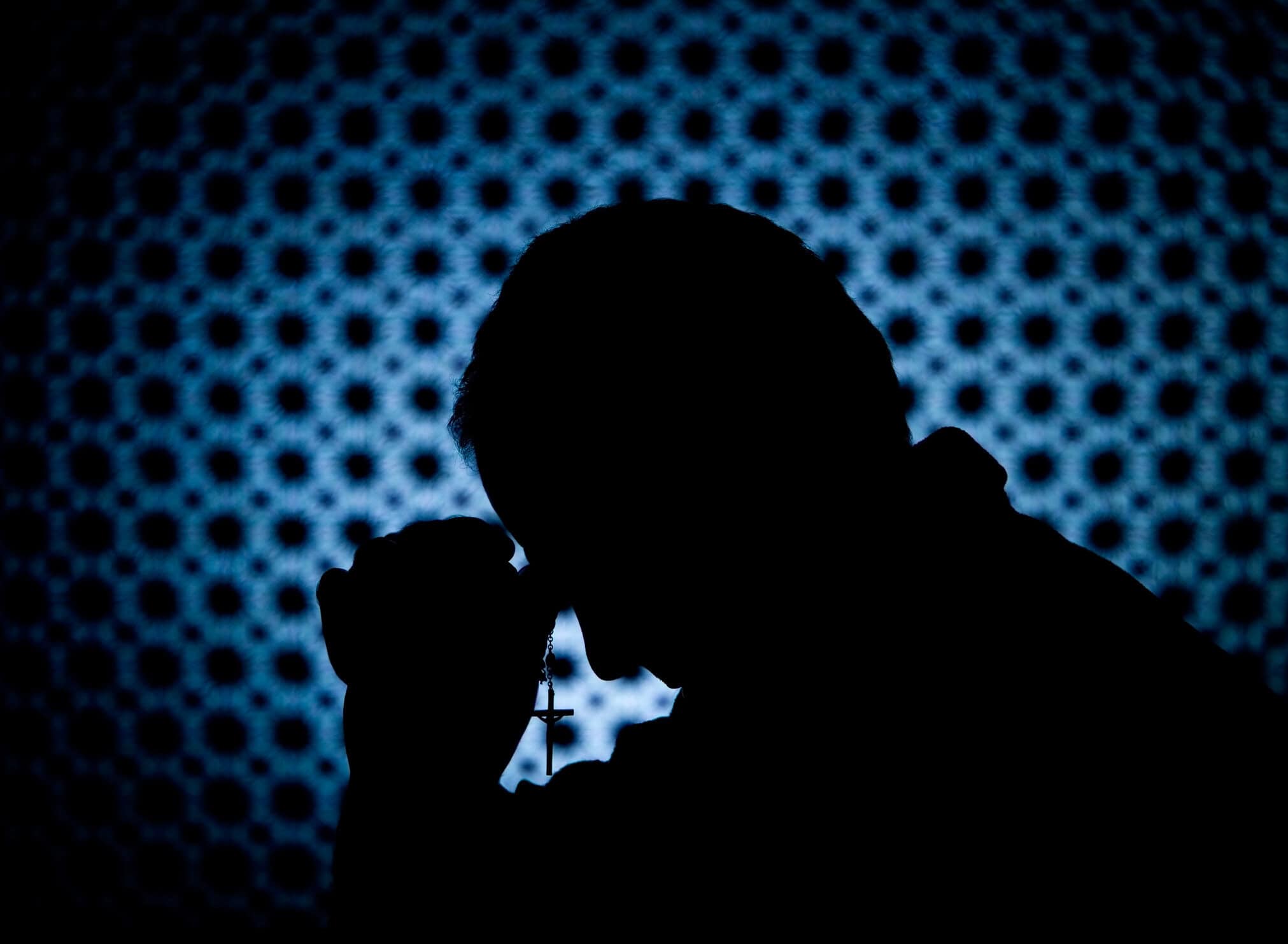 Praying in a confession booth.