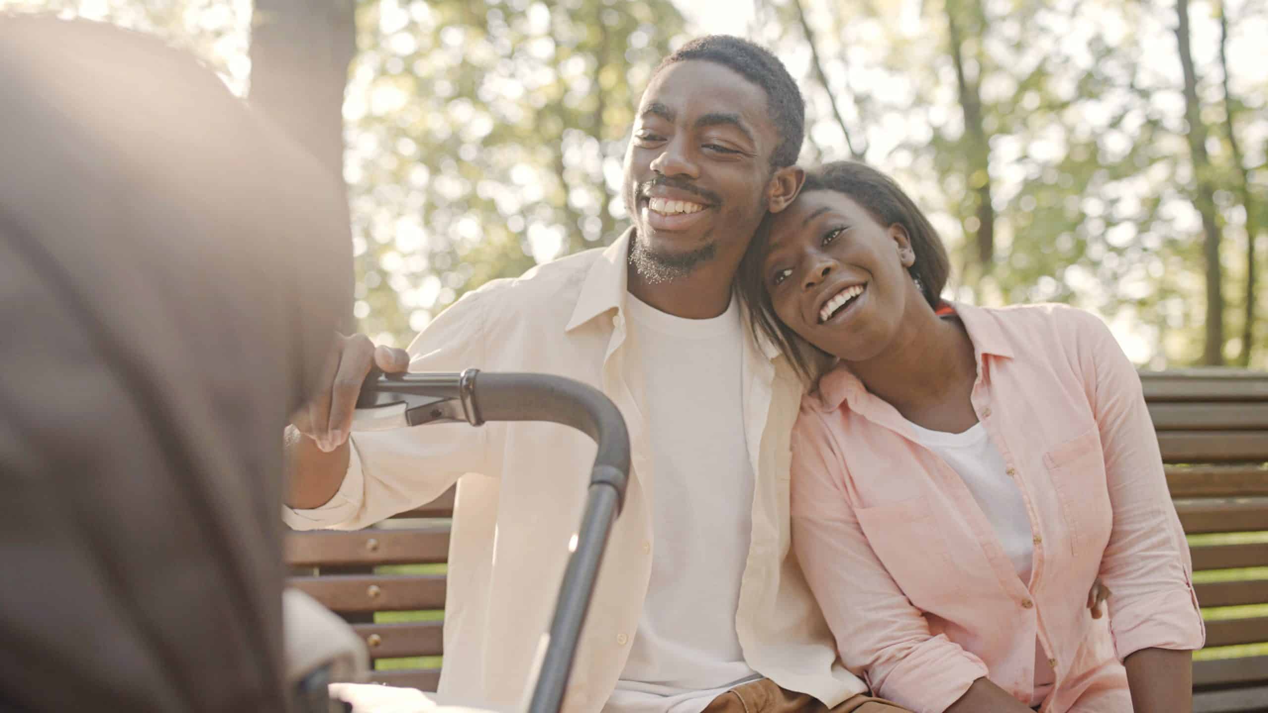 A happy couple outside with a stroller